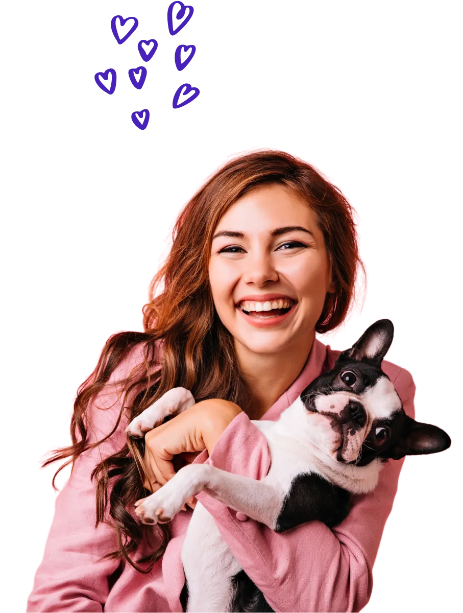 A groomer smiling with a dog